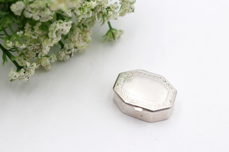 Caixa de comprimidos em prata lisa com gravados geométricos na tampa